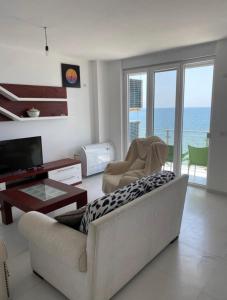 a living room with a couch and a television at Beach Luxury Apartment Shëngjin in Lezhë