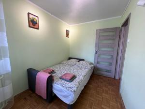 małą sypialnię z łóżkiem i drzwiami w obiekcie Apartament Renata we Wrocławiu