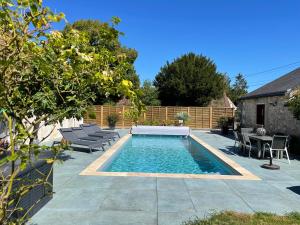 a swimming pool in a backyard with chairs and a table at Le Clos des Buis 2 gîtes 6CH 4 SDB 4 WC in Azay-sur-Cher