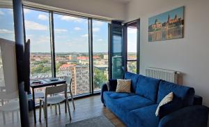 salon z niebieską kanapą i stołem w obiekcie Aleda Tower, 14 floor, balkon w Szczecinie