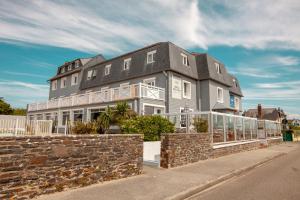 uma casa grande ao lado de uma rua em Hôtel des Isles em Barneville-Carteret