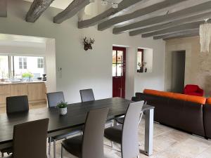 a dining room with a table and a couch at Le Clos des Buis 2 gîtes 6CH 4 SDB 4 WC in Azay-sur-Cher