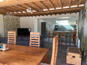 Il comprend un salon et une cuisine avec une table et des chaises. dans l'établissement Charmante maison à deux pas de la mer, à Gouville-sur-Mer