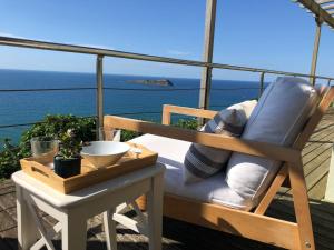 una silla en el balcón con vistas al océano en Adosado en la costa con excelentes vistas al estuario de Urdaibai, en Mundaka