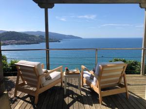 2 sillas en una terraza con vistas al océano en Adosado en la costa con excelentes vistas al estuario de Urdaibai, en Mundaka