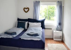 a bedroom with a blue bed and a window at Endless Summer in Tønsberg