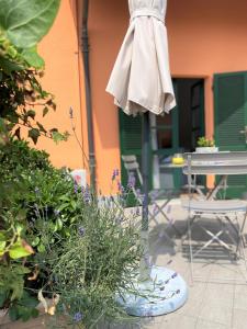 patio con tavolo, ombrellone e alcune piante di La Casa di Ringhiera ad Alba