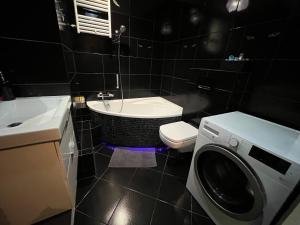 łazienka z toaletą i pralką w obiekcie Apartament Renata we Wrocławiu