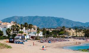 grupa ludzi na plaży z górami w tle w obiekcie CT 158 - Lotus Jardinana by MPS - La Cala de Mijas w Maladze