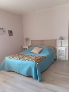 RosièresにあるLe Mas de Magnaouのベッドルーム1室(青い毛布、テーブル2台付)