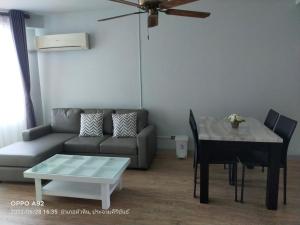 a living room with a couch and a table at Baan Plerd Plern by Golf in Hua Hin