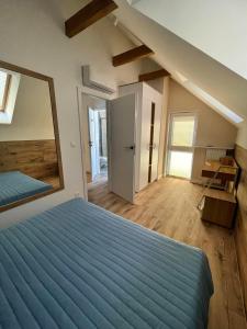 a bedroom with a large blue bed and a mirror at Norda Resort in Dębki