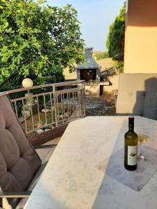 a bottle of wine sitting on a table with a glass at Cosy, sea view apartment Porat in Porat