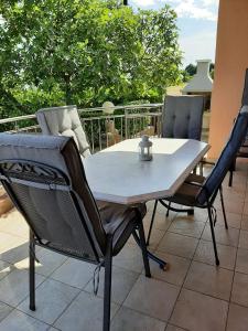 a dining table and chairs on a patio at Cosy, sea view apartment Porat in Porat