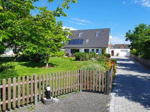 a wooden fence in front of a house at Ferienhaus Meerblick in Pellworm