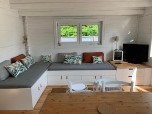 ein Wohnzimmer mit einem Sofa und einem Tisch in der Unterkunft Cottage Le Cerf-volant in Saint-Aubin-sur-Mer