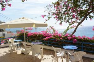 a patio with tables and chairs and pink flowers at Hotel Hariklia in Agia Galini