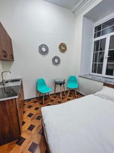 a bedroom with a bed and two green chairs at Apartments Tumanyan in Yerevan +8 photos