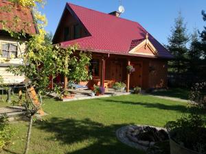 dom z czerwonym dachem i dziedzińcem w obiekcie Willa Skrzat w mieście Danowskie