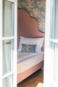 uma cama com cabeceira num quarto em Hotel Goldener Ochs em Bad Ischl