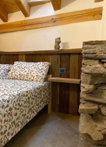 ein Schlafzimmer mit einem Bett und einer Steinmauer in der Unterkunft Chez Orsille in Aymavilles