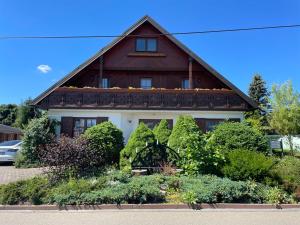 ein Holzhaus mit einem Garten davor in der Unterkunft Zum Geigenmüller in Stützengrün