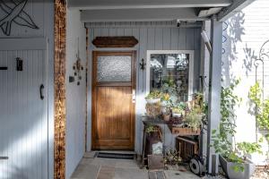 uma porta de madeira numa casa com plantas em Hus Tidevann em Tönning