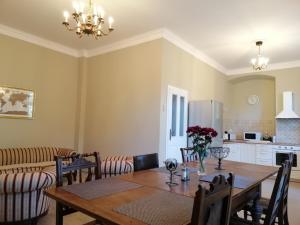 a dining room with a table and a kitchen at Apartmán Fara in Včelákov