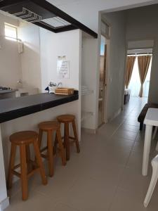 a kitchen with a counter and stools in a room at Villa Alejandra in Ricaurte