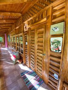 Habitación de madera con puertas de madera y suelo de baldosa. en Cabañas Lamaite, en Sámara