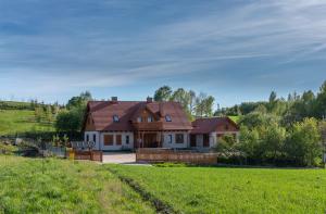 een huis in een veld met een groen veld bij Farwna Checz in Chmielno