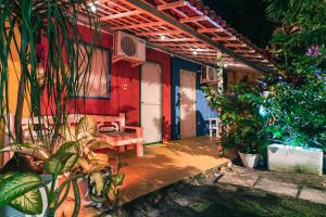 a patio of a house with a bench and plants at Pousada Cambará in Tamandaré