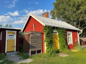 a red and yellow house with ivy growing around it at Abbis lillstuga 