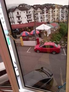 a red car is parked in a parking lot at CH Budget Hotel in Cameron Highlands