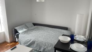 - une chambre avec un lit et une table avec des plaques de cuisson dans l'établissement Les Studios de Clément, à Poitiers
