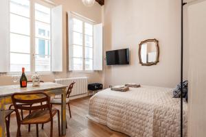 een slaapkamer met een bed, een tafel en een spiegel bij La conchiglia in Lucca