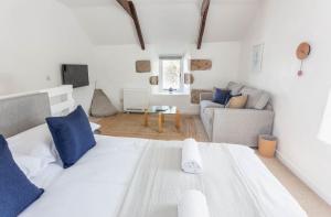 ein weißes Schlafzimmer mit einem großen Bett und einem Sofa in der Unterkunft Cosy 1 bedroom Cottage - Great location & Parking in Penzance