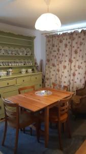 a wooden table and chairs in a room with a kitchen at Le Liseron in Leysin