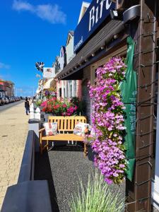 a bench in front of a store with flowers at Birch Villa in Blackpool