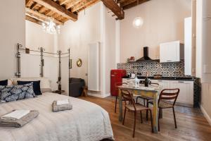 a bedroom with a bed and a table and a kitchen at La conchiglia in Lucca