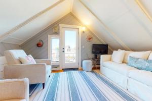 a living room with a white couch and chairs at Monument View in Provincetown