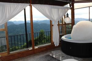 uma casa de banho com banheira e vista para as montanhas em el paraíso de Butulú 1 em La Vega