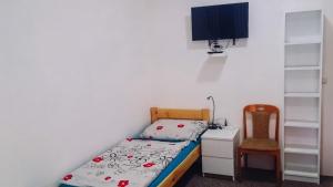 ein kleines Schlafzimmer mit einem Bett und einem Stuhl in der Unterkunft Penzion u Karla 