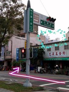 ein Straßenschild und eine Ampel mit einem rosa Pfeil in der Unterkunft Go Home Homestay in Kaohsiung