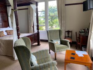 a bedroom with a bed and two chairs and a table at The Old Vicarage NI B&B in Ballywalter