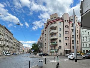 budynek przy ulicy miejskiej z zaparkowanymi samochodami w obiekcie Apartament Renata we Wrocławiu