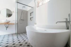 a bathroom with a large white tub and a sink at Silvia Como House - The House Of Travelers in Como