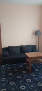 Sala de estar con sofá azul y mesa de centro en Penzion Gremium, en Bratislava