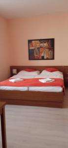 um quarto com uma cama com lençóis vermelhos e brancos em Penzion Gremium em Bratislava