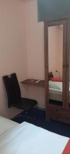 a bedroom with a mirror and a chair and a bed at Penzion Gremium in Bratislava